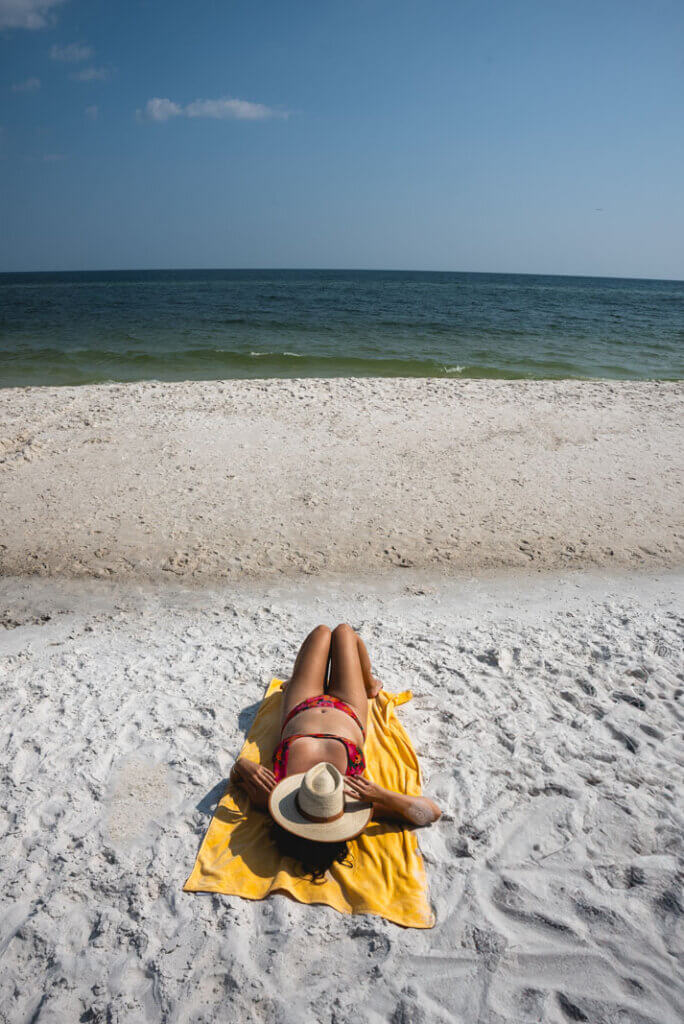 Megan laying at the beach at the The Lodge at Gulf State Park in Gulf Shores Alabama