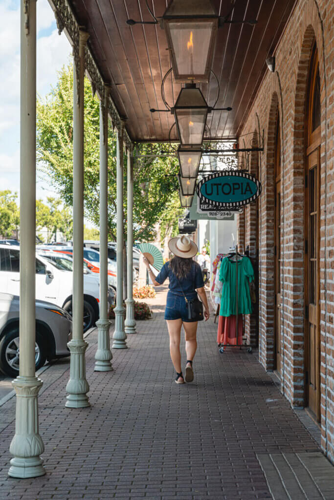 Megan walking in front of shops in Fairhope French Quarter in Fairhope Alabama
