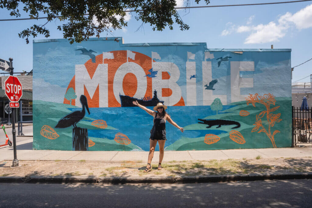 megan in front of Mobile mural in the Old Dauphin Way Historic District in Mobile Alabama