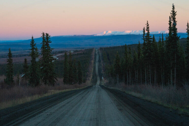 Driving the Dalton Highway along the Trans Alaska Pipeline on an Arctic Circle tour in Alaska at dusk