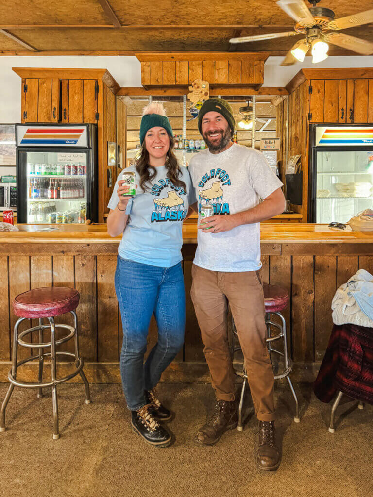 Megan-and-Scott-with-their-souvenir-shirts-at-Coldfoot-Camp-on-the-Arctic-Circle-tour-in-Alaska