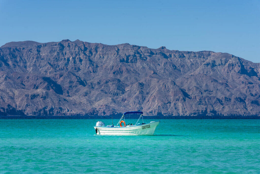 A beautiful scene of a boat in turquoise water at Coronada Island in Loreto Mexico