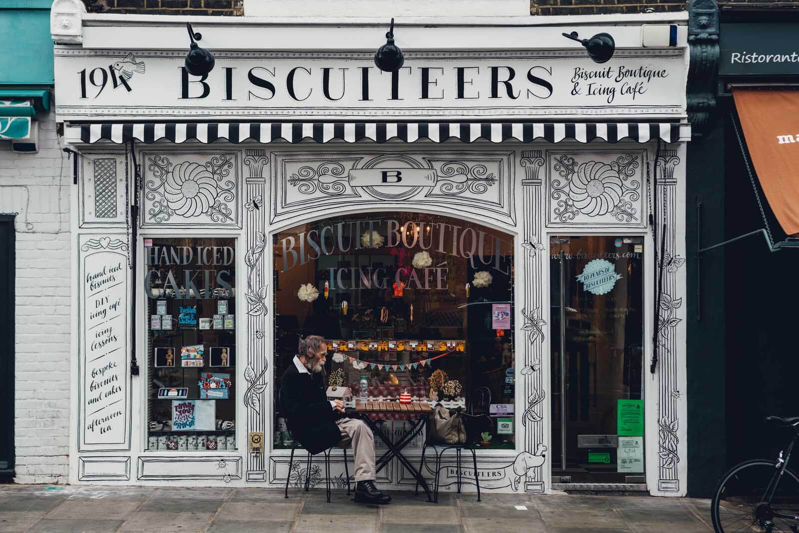 man sitting at Biscuiteers Bakery and Icing Shop in London