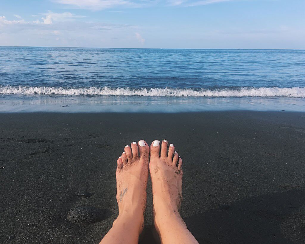 Black Sand Beach Amed Beach -- feet with white nail polish
