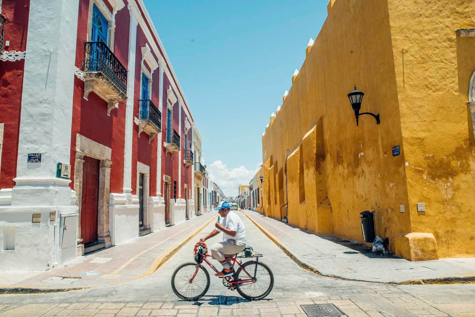 Man cycling down the streets of Campeche Mexico