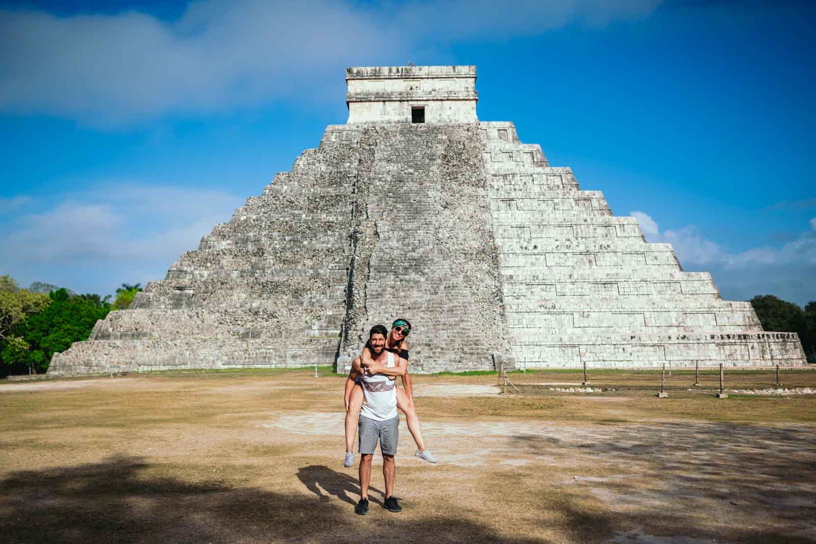 A couple poses in front of Chichen Itza