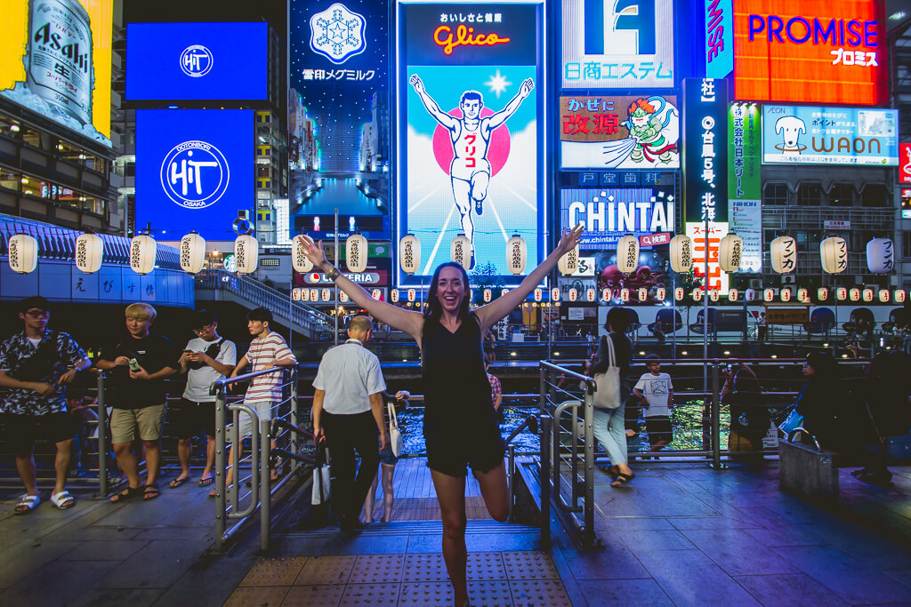 girl doing the Glico Man sign in Dotonbori Osaka