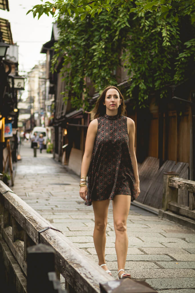 Girl in short patterned dress walking on streets of Gion