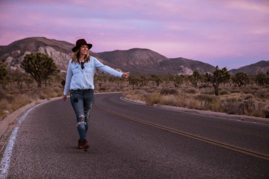 Megan hitch hiking in the road at Joshua Tree