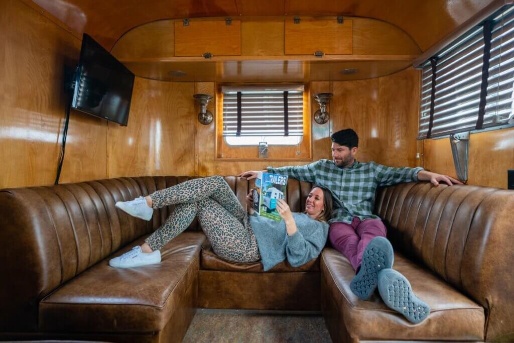 Megan and Scott hanging out in their vintage trailer at Waypoint Ventura in California
