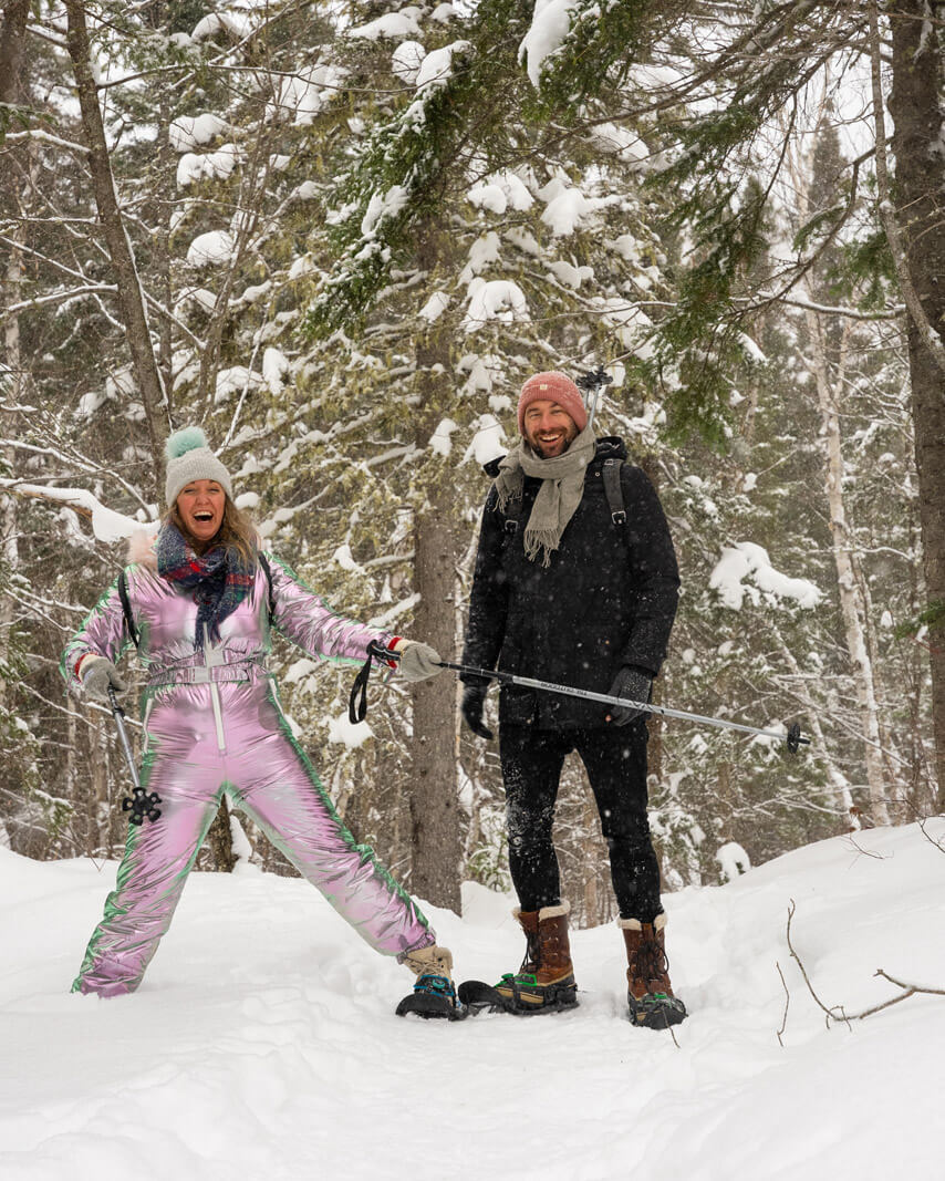 Megan and Scott laughing and falling snowshoeing in Monts Valin National Park in winter in Saguenay lac saint jean quebec