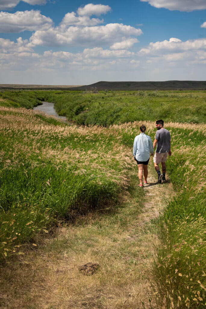 Megan and Scott walking through a pretty pathway in Grasslands National Park West Block in Saskatchewan Canada