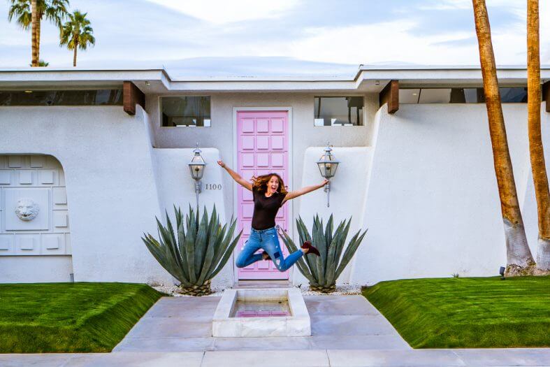 Megan jumping in front of that pink door famous house in palm springs