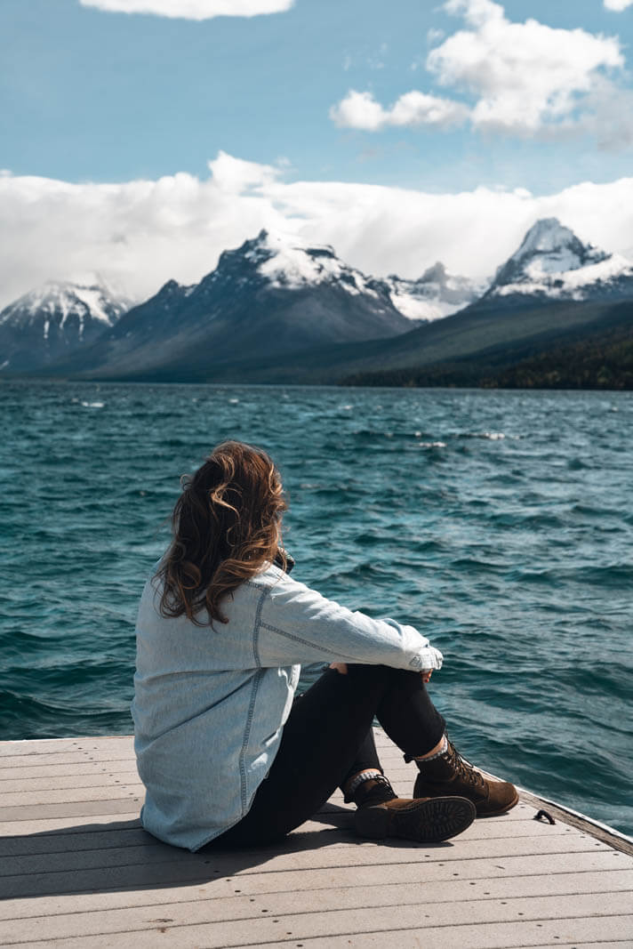 Megan enjoying the view of Glacier National Park mountains across from Lake McDonald at Apgar in Montana