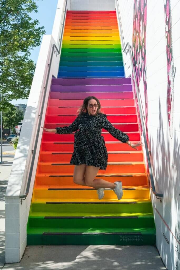 Megan jumping down the rainbow stairs at the Mosaic District in Fairfax County VA