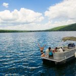 Megan jumping off pontoon boat in Keuka Lake in the Finger Lakes New York