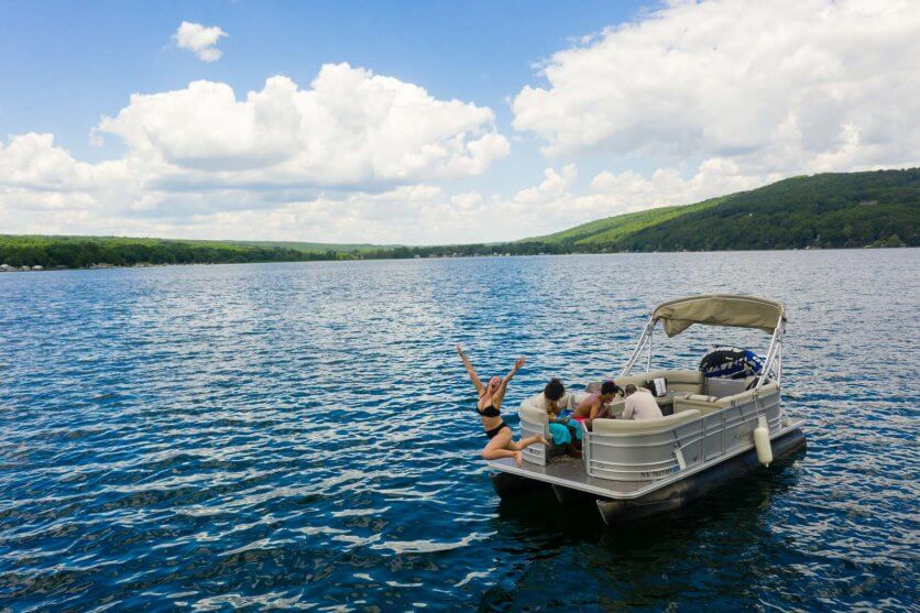 Megan jumping off pontoon boat in Keuka Lake in the Finger Lakes New York