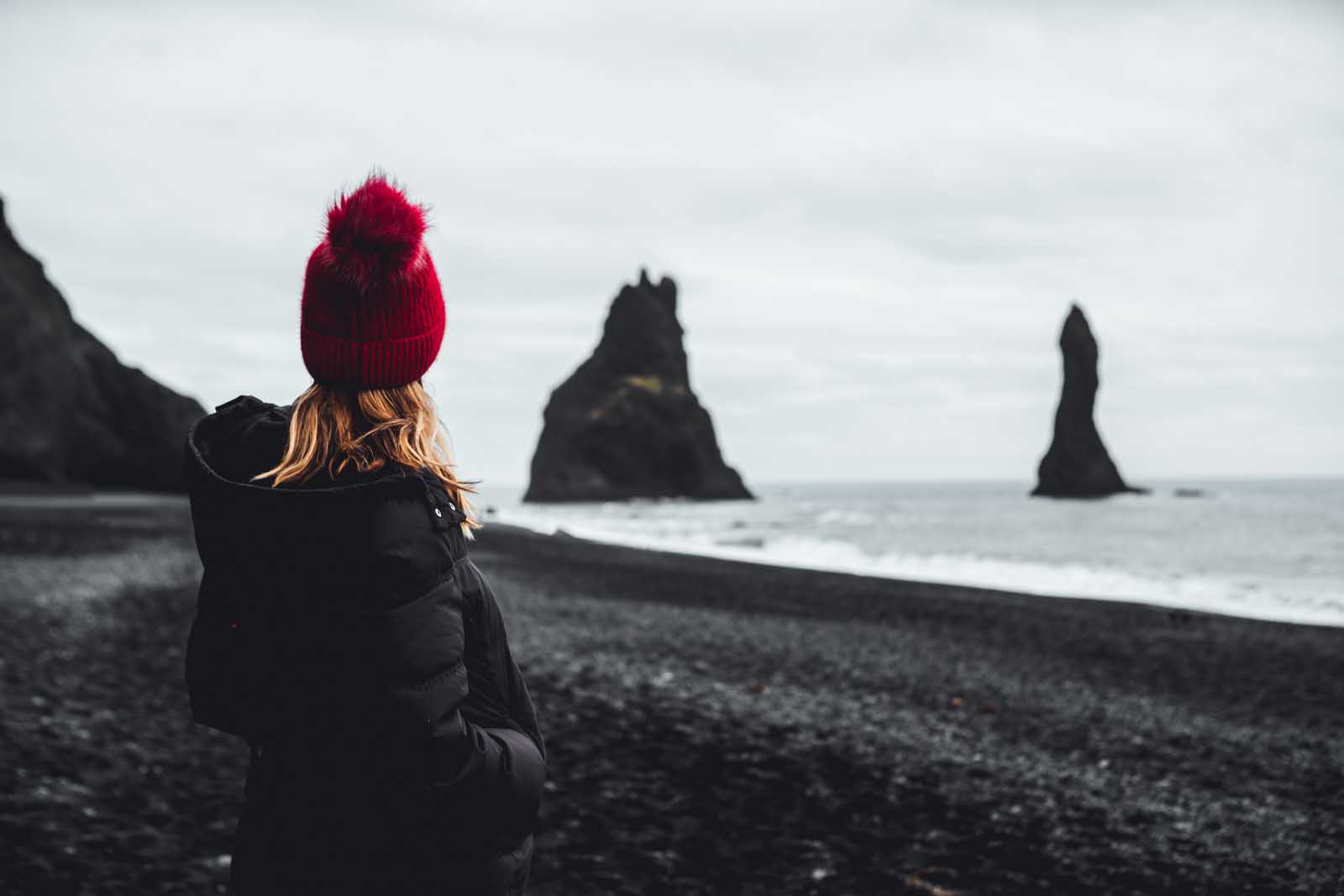 Megan looking at the rocks in the ocean at Reynisfjara Beach