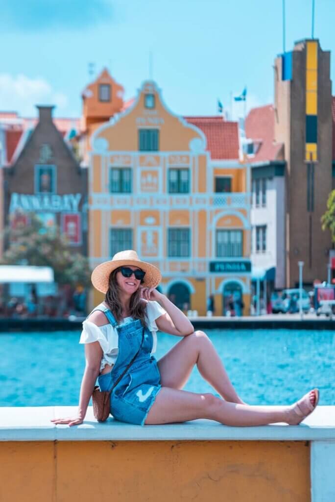 Megan posing in Otrabanda in Willemstad Curacao with Handelskade colorful buildings in the backdrop