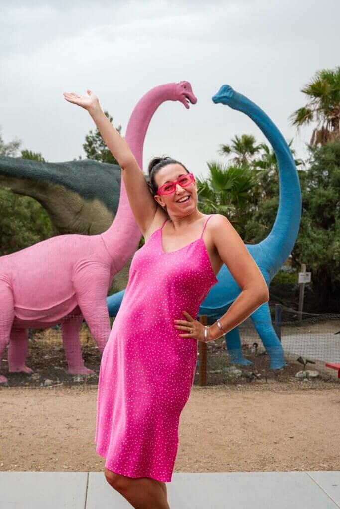 Megan posing with colorful dinosaurs at the Cabazon Dinosaurs near Palm Springs California