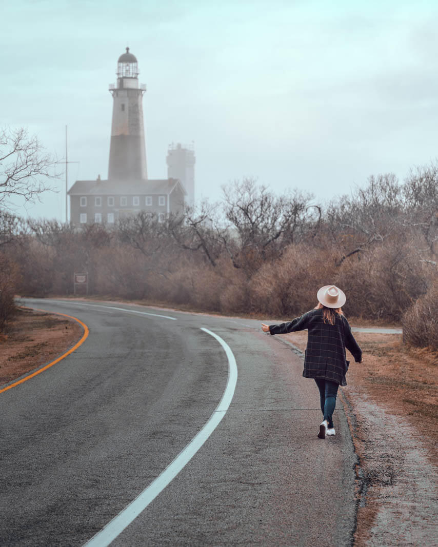 Megan pretending to hitchhike in the hamptons new york at Montauk Point Lighthouse