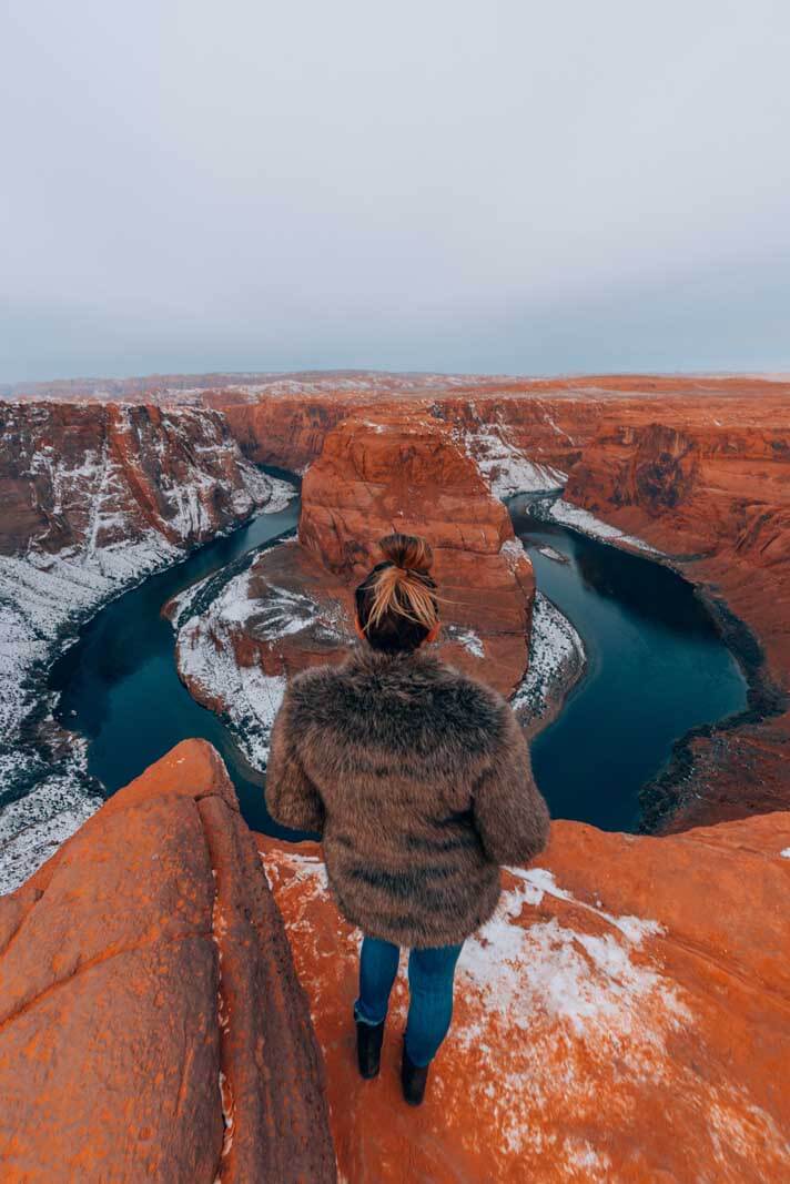 Megan standing near the edge of the cliff at Horseshoe Bend