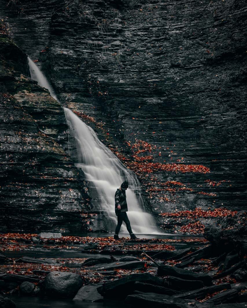 Megan walking under the waterfall at Grimes Glen Park in Naples New York