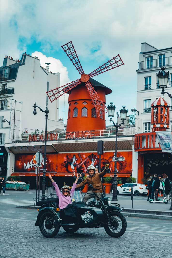 Posing on our motorcyle in front of Moulin Rouge with our guide Romain