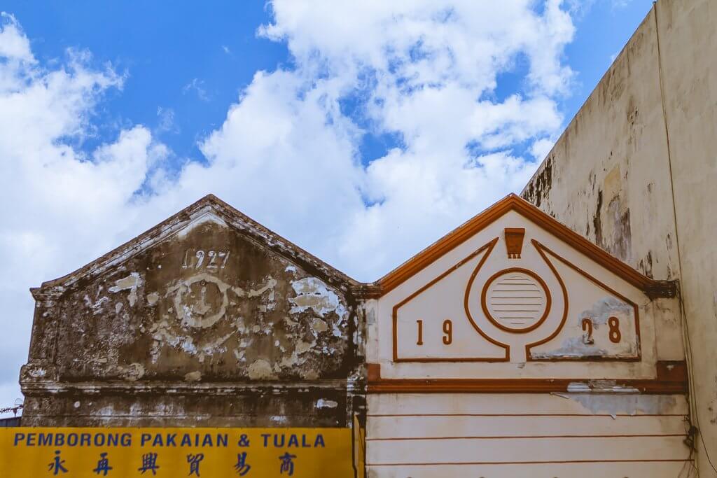 Georgetown Penang - twin roofs, one is older and says 1927, the other is white with red trim and says 1928