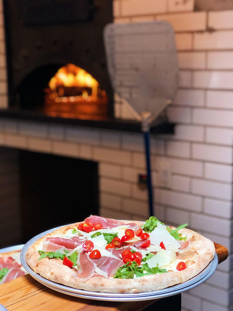 a pizza fresh from the wood fire oven at Emporio Nolita Restaurant