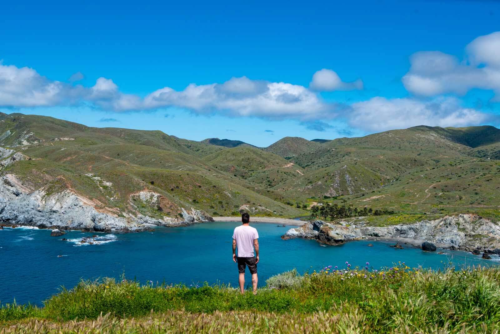 Scott standing on the back side of Catalina Island with an incredible view of Little Harbor