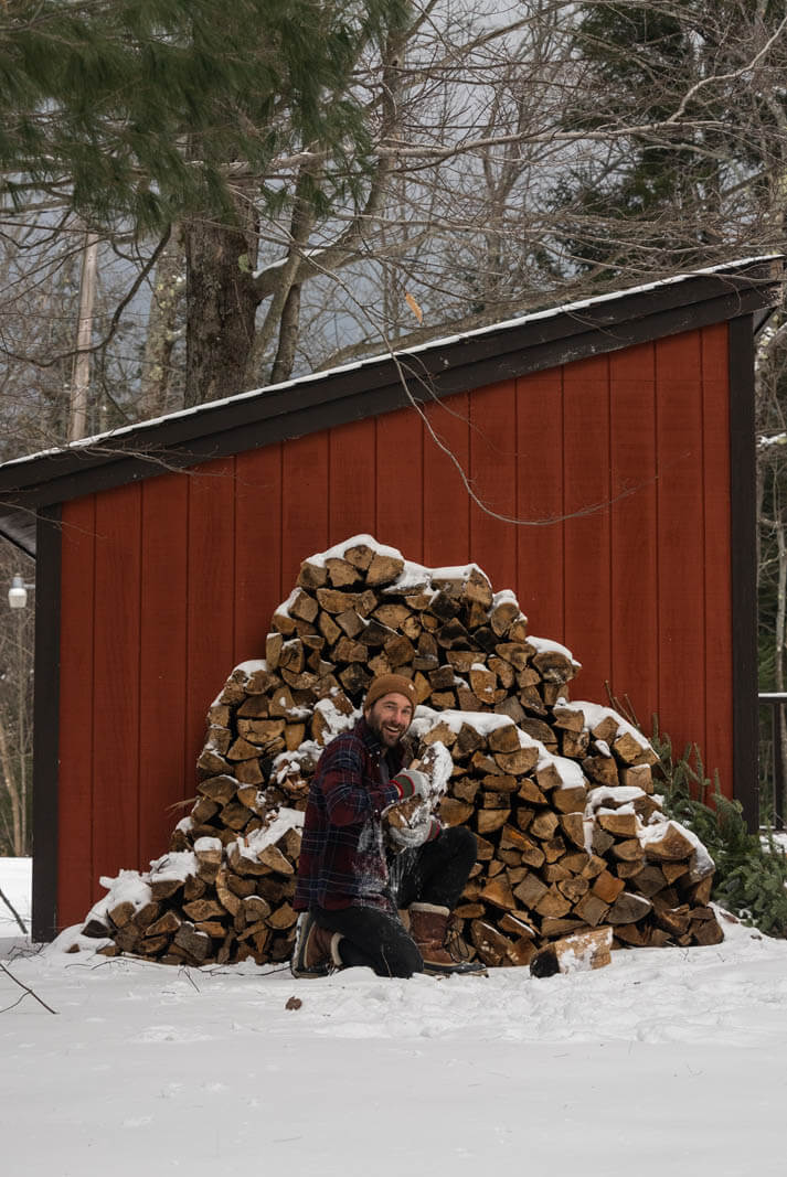 Scott grabbing firewood at our Vermont cabin getaway in Dover VT in winter