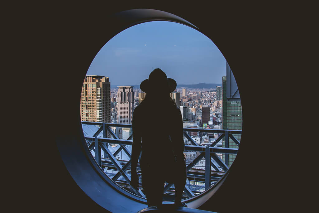 outline of girl looking out window at Umeda Tower Observatory