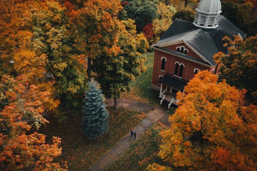 aerial shot of Megan and Scott walking to Naples Memorial Town Hall in New York Finger Lakes region in the fall