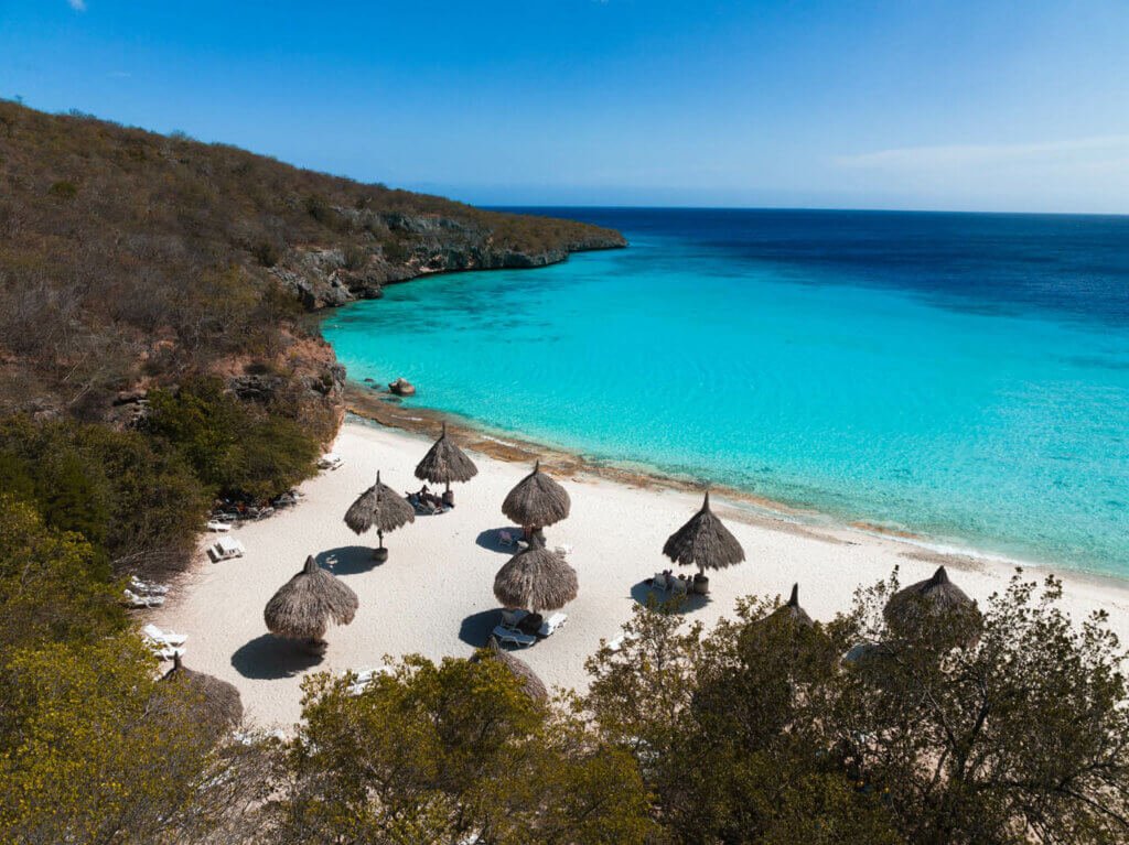 aerial view of the palapa umbrellas and white sand at Cas Abao Beach in Curacao