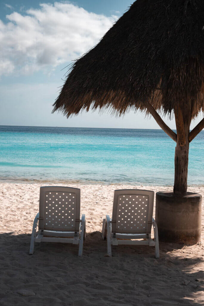 beach chairs under a palapa umbrella at Playa Cas Abao in Curacao