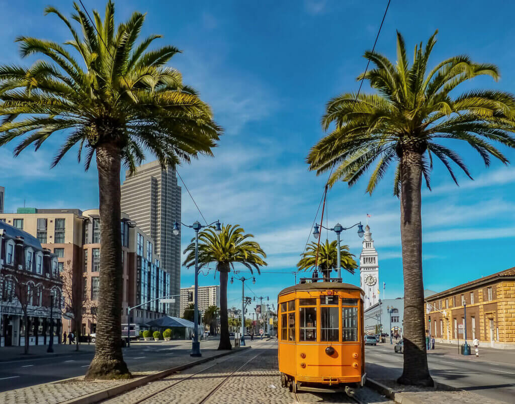cable-car-in-Embarcadero-in-San-Francisco-with-the-ferry-building-in-the-background