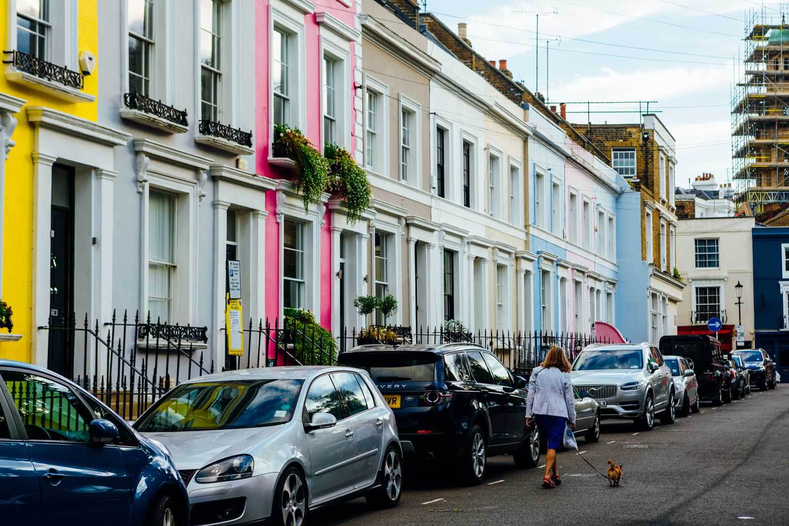 lady walking dog in colorful street in London 
