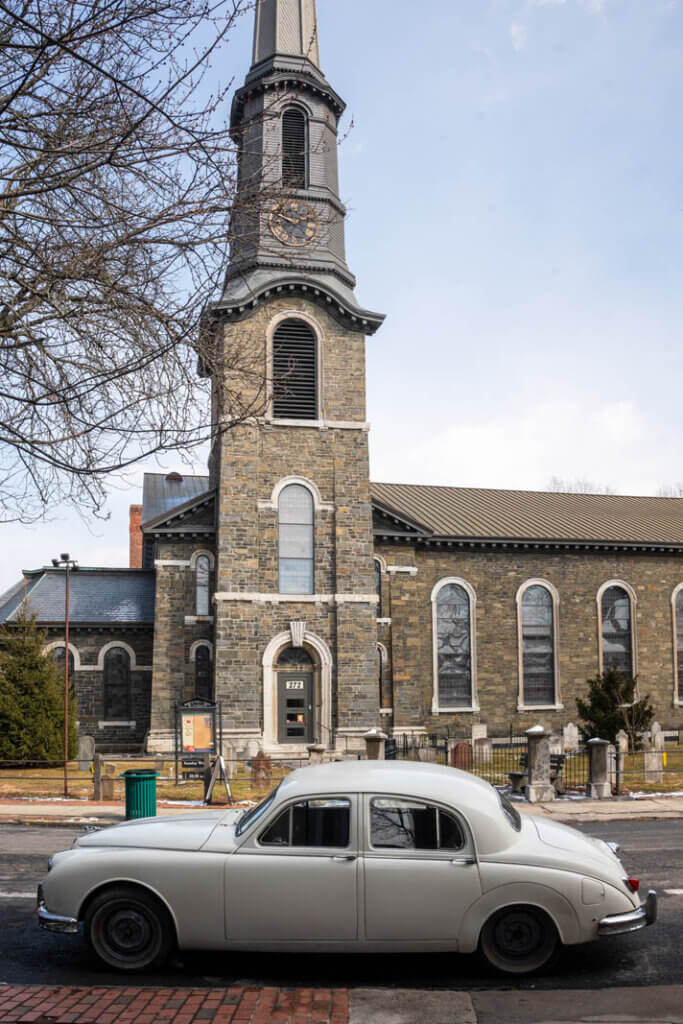 cool old car parked outside the Old Dutch Church in Kingston New York in the Hudson Valley