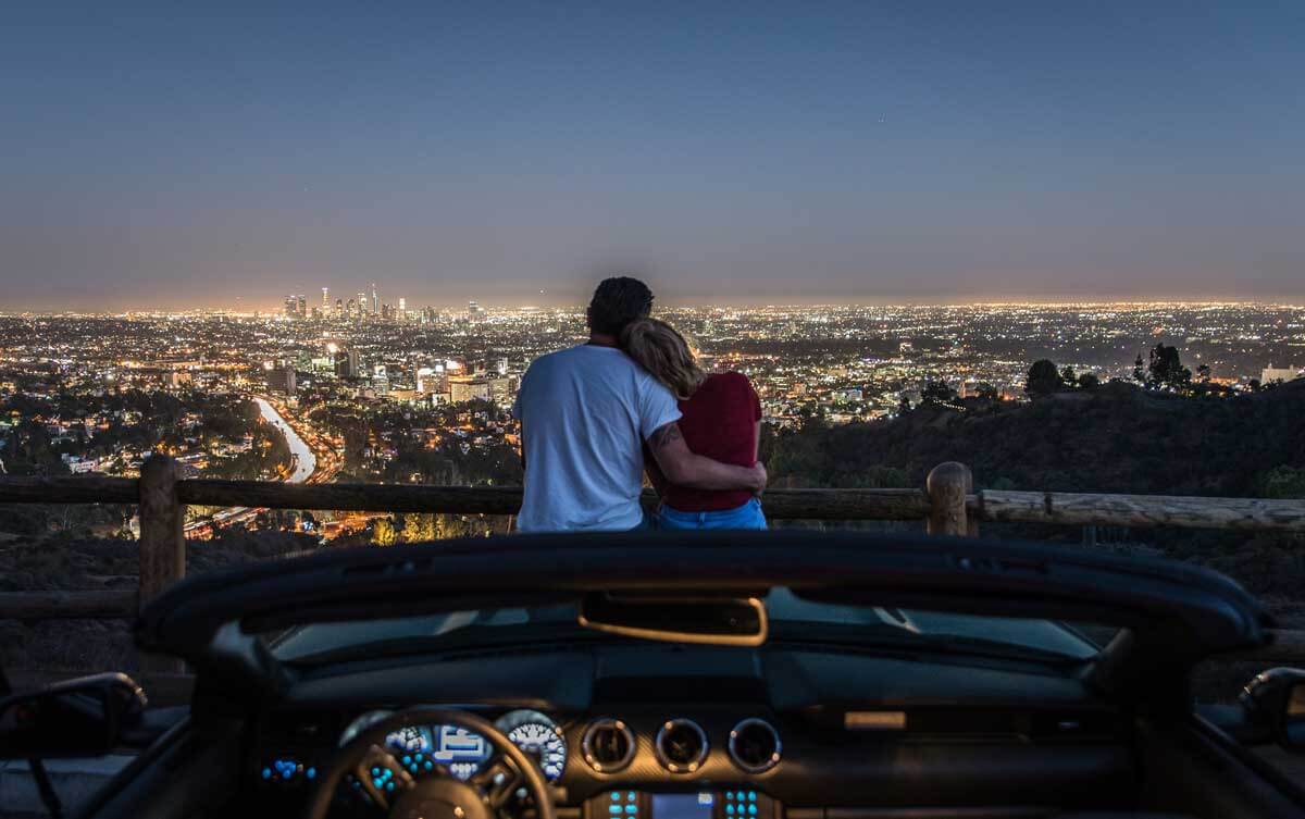 couple-enjoys-a-romantic-drive-along-Mullholland-Drive-in-Los-Angeles-for-a-view-at-night