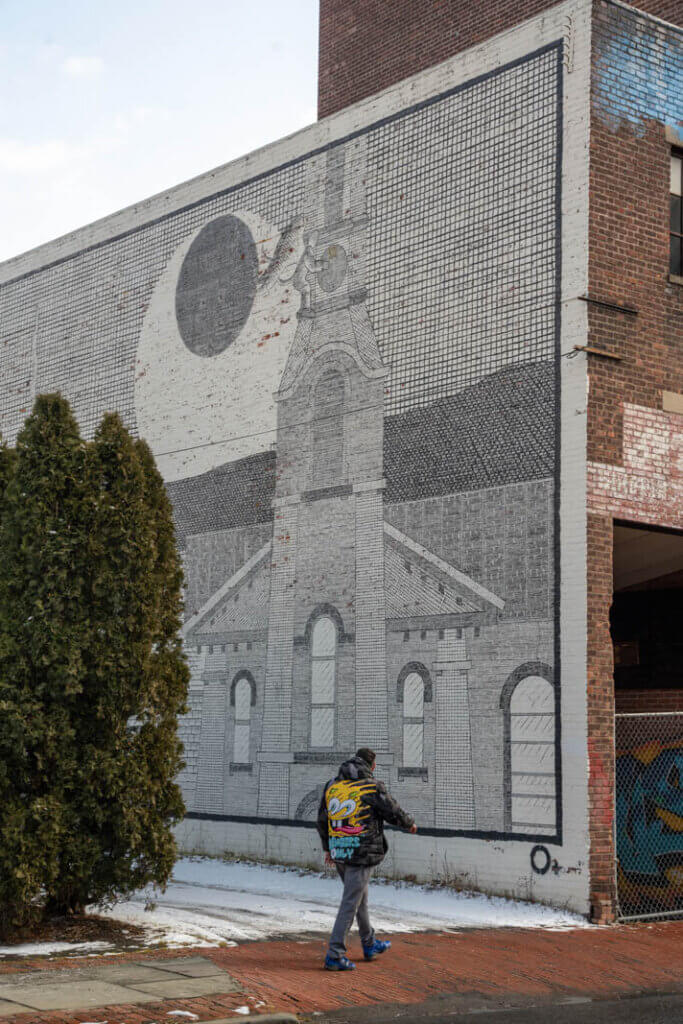 man walking in front of a mural in the Stockade District in Kingston New York