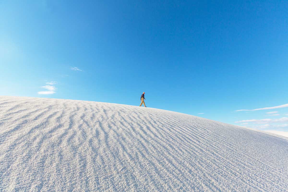 man-walking-on-the-white-sands-national-park-sand-dunes