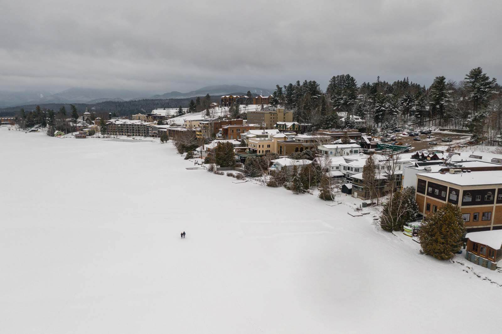 people walking on the frozen mirror lake at Lake Placid in winter in the Adirondacks new york