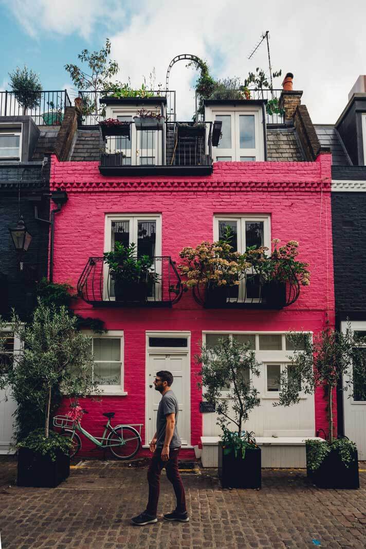 Scott walking across pink house in St Lukes Mews in London