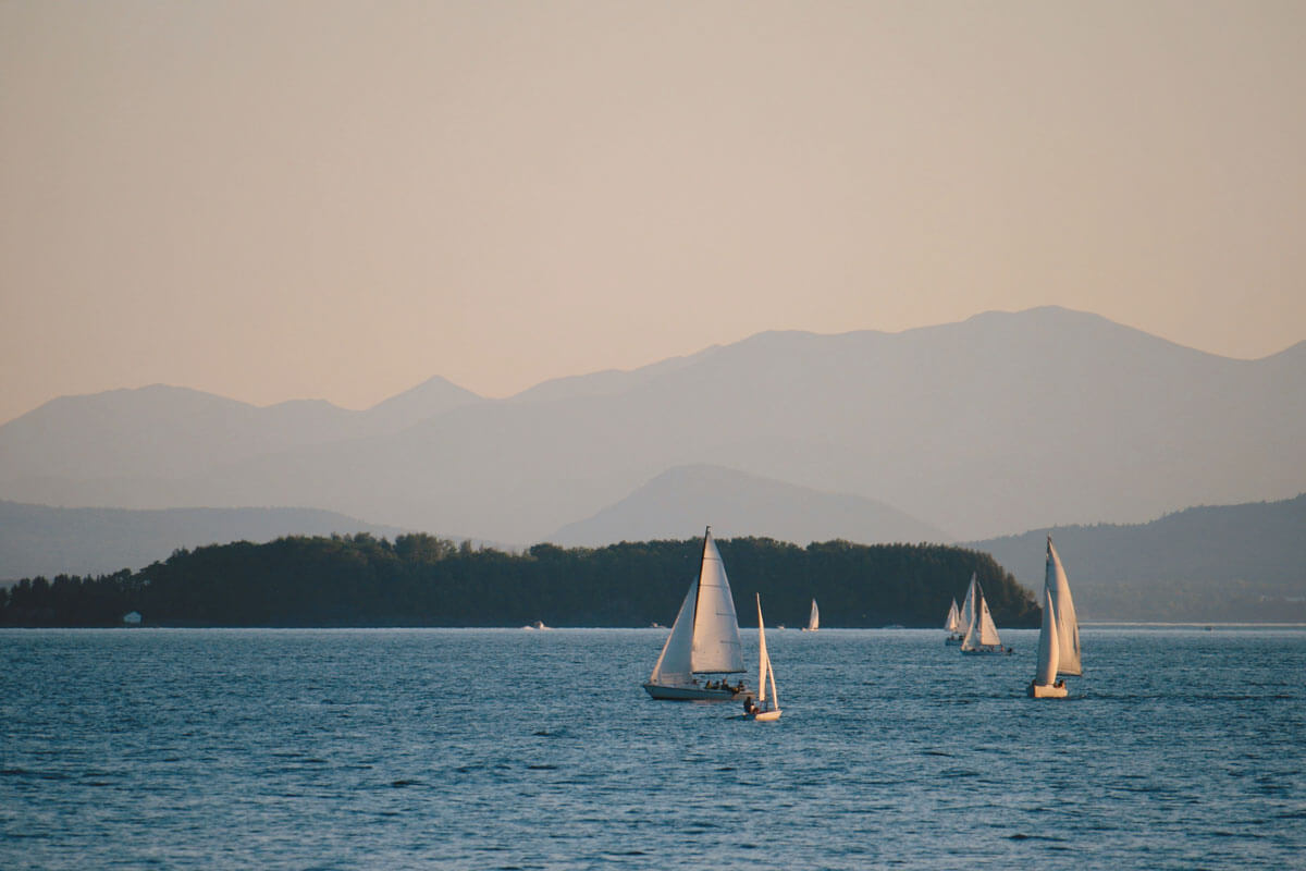 sail-boats-on-Lake-Champlain-with-the-Adirondack-Mountains-in-the-backdrop-in-Vermont-and-New-York