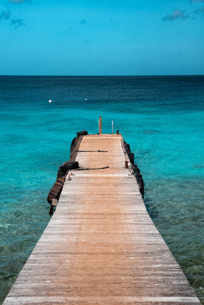 the pier and clear blue water at Playa Kalki in Westpunt Curacao