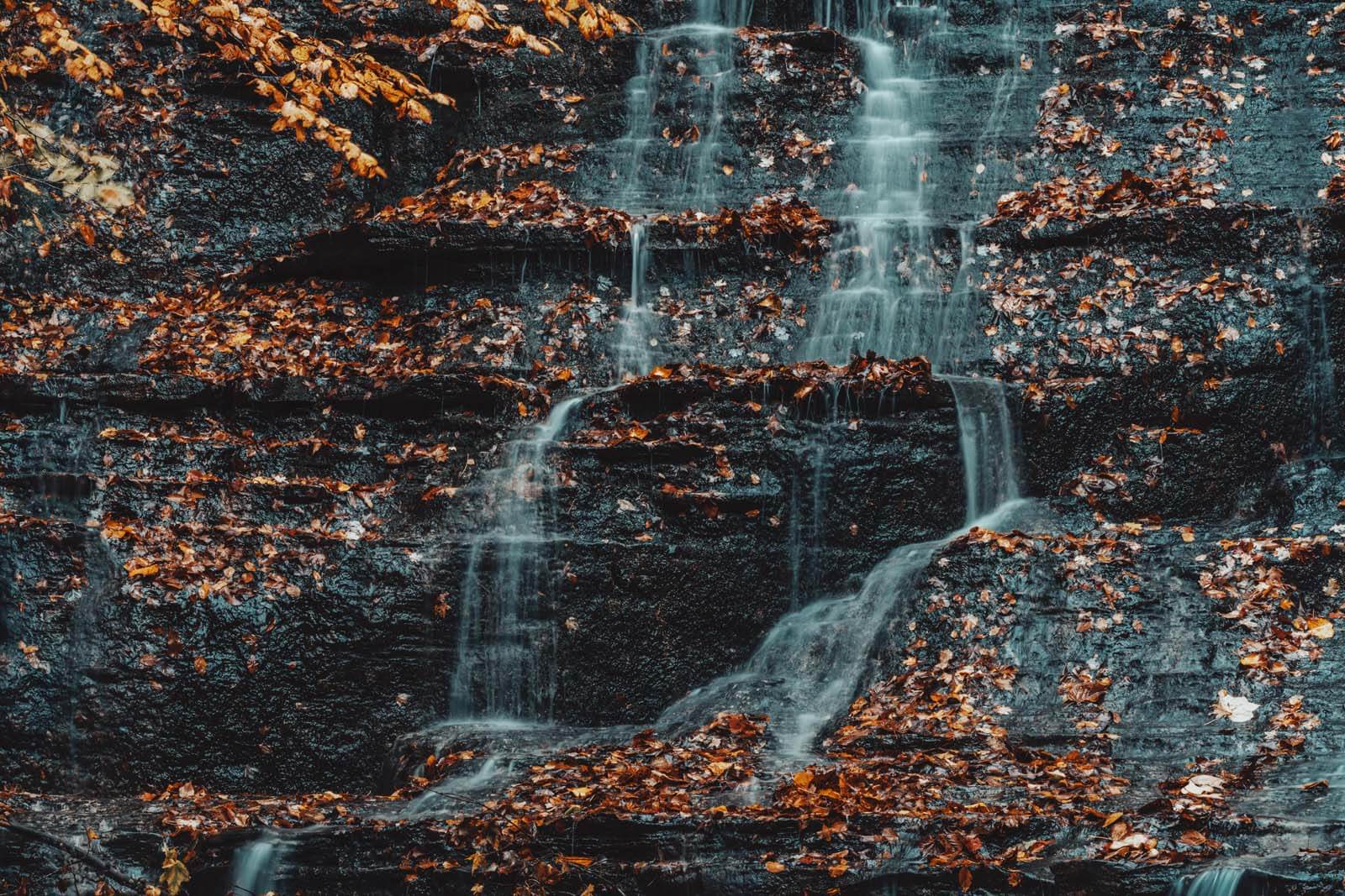 water cascading down the falls in Grimes Glen Park in Naples New York in the fall