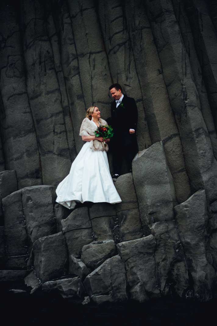 bride and groom on the rock formations at Renisfjara Beach in South Iceland