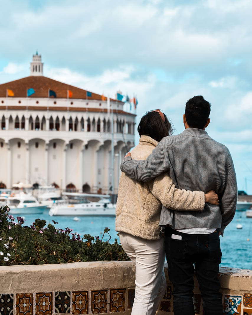 weekend getaway to Catalina Island in California a couple looks at the ocean with the Casino in the background